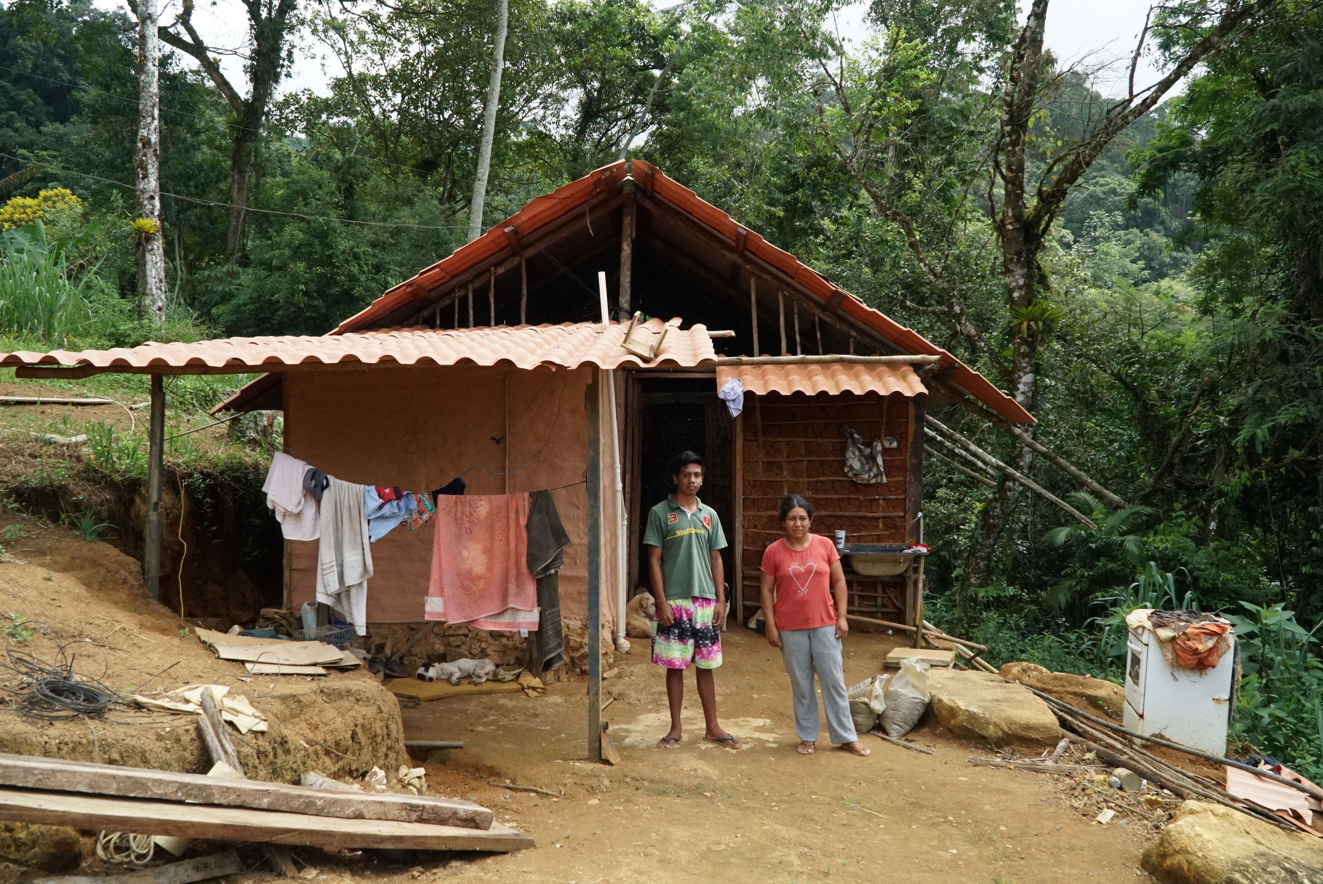 Gabriel da Silva Martins -Wera- posa junto a su madre frente a su casa en la aldea guaraní Araponga, donde ha trabajado en la construcción del sistema de saneamiento básico.