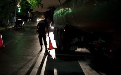 Un policía en un control de tráfico durante la primera noche de los cortes de luz decretados para ahorrar energía.