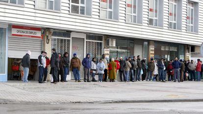 Diverses persones formen una llarga cua davant una oficina de l'INEM. EFE/Archivo
