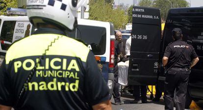 Dos policías observan el traslado de la mujer fallecida.