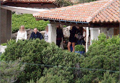 Berlusconi pasea, acompañado por varias mujeres, por la mansión Villa Certosa", en Cerdeña, en una de las fiestas que organizaba el primer ministro italiano.