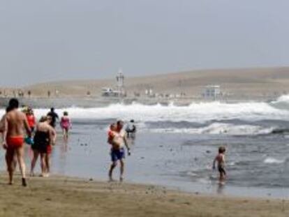 Los turistas pasean por la playa de Maspalomas en la isla de Gran Canaria.