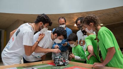 Tres miembros del jurado verifican si el robot de los concursantes ha funcionado correctamente durante el torneo de robótica, en Cáceres.