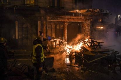 Un manifestante intenta apagar un fuego en una calle de París.