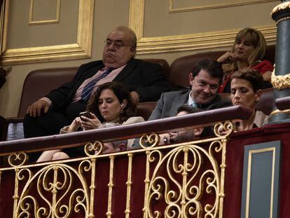 La presidenta de la Comunidad de Madrid, Isabel Díaz Ayuso, y el presidente de la Junta de Castilla y León, Alfonso Fernández Mañueco, durante la primera sesión del debate de investidura de Pedro Sánchez como presidente de Gobierno, en el Congreso de los Diputados.