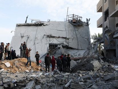 Un grupo de palestinos, junto a una casa destruida por un bombardeo israelí en Rafah, al sur de la franja de Gaza.