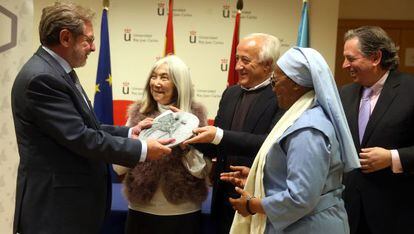 Juan Luis Cebrián recibe el premio de manos de los representantes del Foro Ecuménico Social.