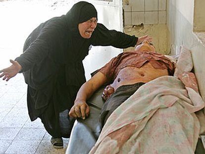 Una mujer llora ante el cadáver de su hijo, fallecido en el atentado de ayer en Bagdad.