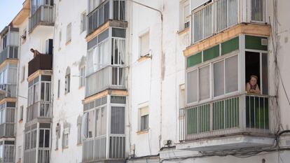 Una vecina se asoma al balcón de su piso en uno de los edificios afectados en el Cerro del Moro (Cádiz).
