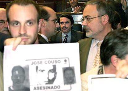 Un periodista sujeta una pancarta con el nombre de José Couso  frente al presidente Aznar.