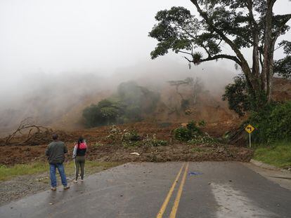 Dos personas observan una carretera bloqueada tras el derrumbe en Rosas, departamento del Cauca (Colombia) que dejó más de 900 personas afectadas