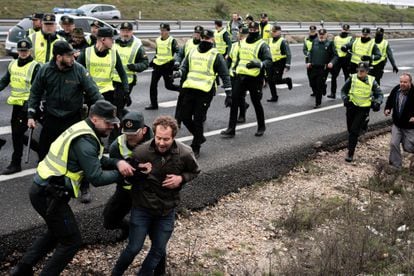 Varios agentes de la Guardia Civil detrás de un agricultor durante una concentración en la autovía A-42, en Illescas (Toledo), el 9 de febrero. 
