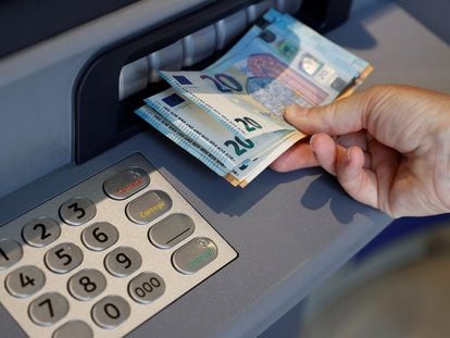 Una persona saca dinero de un cajero de una entidad bancaria, en Madrid.