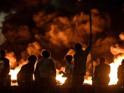 Un grupo de jóvenes observa los neumáticos incendiados que bloquean una calle en Burdeos, la noche del pasado jueves.