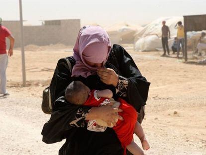 Una mujer siria camina junto a su hijo en el campo de refugiados de Zaatari, en Jordania. 