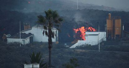 Lava rolls down behind a cement factory in Los Llanos as the Cumbre Vieja volcano continues to erupt on the Canary Island of La Palma, as seen from Tajuya, Spain, October 11, 2021. REUTERS/Sergio Perez