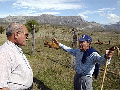 Agustín Alonso, a la izquierda, y Pepe González hablan de la Guerra Civil ante la cumbre de Peña Laza.