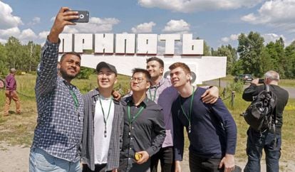 Turistas haciéndose un selfi con el cartel de la localidad ucrania al fondo.