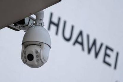 Cámara de vigilancia junto a un letrero de Huawei en Pekín.