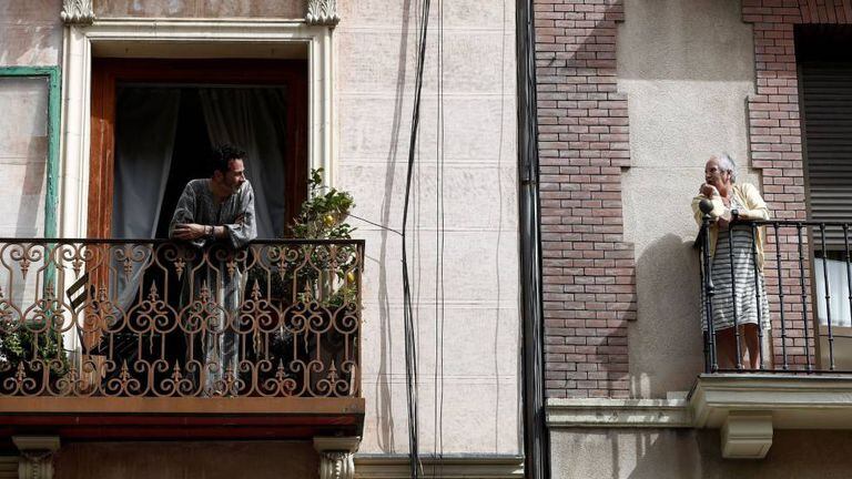 Dos vecinos conversan en el balcón de sus casas en Madrid.