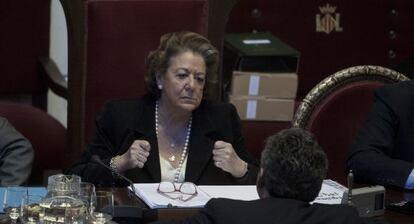 La alcaldesa de Valencia, Rita Barberá, habla con un concejal durante el pleno.