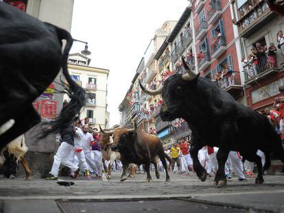 Uno de los toros de la ganadería madrileña de Victoriano del Río golpea a un mozo en la calle de La Estafeta durante el sexto encierro de los Sanfermines.
