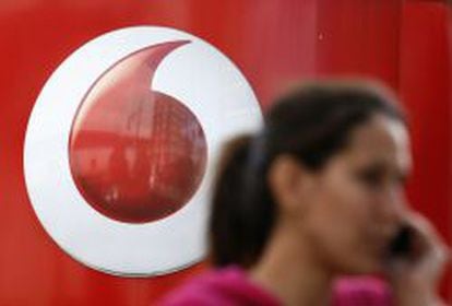Una mujer pasea delante de una tienda de Vodafone de Londres