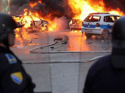 Polic&iacute;as bosnios intentan impedir el pasado viernes un ataque de manifestantes.