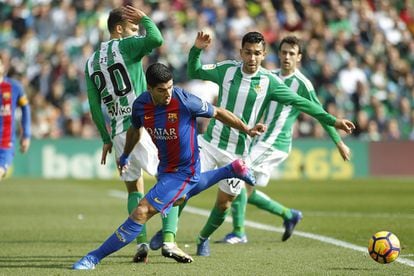 Luis Suárez, del Barcelona. trata de marcharse de varios defensas del Betis.