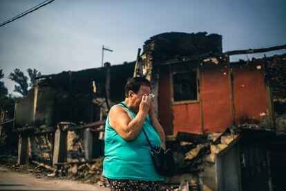 Una mujer llora este miércoles ante el estado en el que han quedado las casas en la aldea de Alixo, en Galicia, donde el domingo y el lunes las llamas devoraron una quincena de viviendas. 