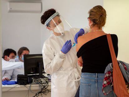 Personal sanitario vacuna a una mujer contra la covid en el recinto del antiguo hospital Son Dureta, este martes en Palma de Mallorca.