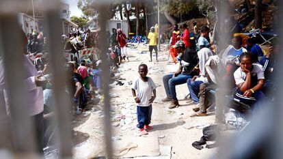 Un niño frente a la entrada del centro de acogida de inmigrantes de Lampedusa, el sábado.