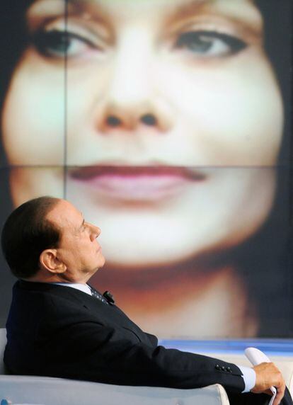 El primer ministro italiano, Silvio Berlusconi ante una pantalla con un retrato de su esposa, Veronica Lario, durante el programa de la televisión italiana 'Porta a porta'.