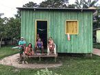 Vecinos de la aldea de Punã ante su vivienda. Punã, Brasil, junio de 2021.