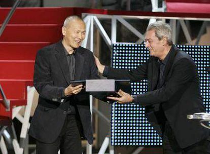 El realizador Wayne Wang recibe la Concha de Oro de manos del escritor Paul Auster, ayer en San Sebastián.