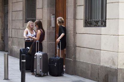 Un grupo de turistas esperan delante de un piso de alquiler en Barcelona