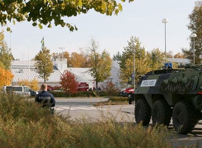 Una tanqueta de la policía y un agente apostados frente a la escuela donde se ha producido el tiroteo.