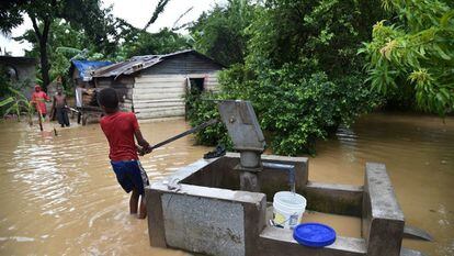 Un niño extrayendo agua en zona inundada luego del Huracán Matthew, en Haití.