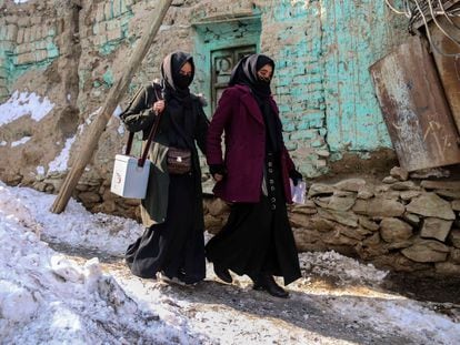 Dos mujeres caminan por las calles nevadas de Kabul para llevar vacunas contra la polio, el pasado 25 de enero.