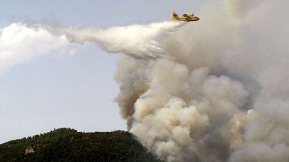 Un avión suelta agua sobre el incendio de Torremanzanas.