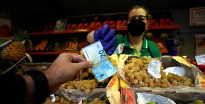 Un hombre comprando en el mercado de la plaza de Lugo de A Coruña.