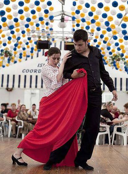 Una pareja bailando en una caseta de la Feria de Abril.