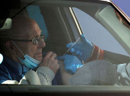 Un hombre es vacunado contra la covid dentro de su coche, este jueves en Hyde, Reino Unido.