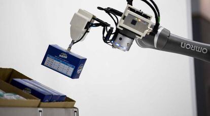 Un robot ordena objetos con su brazo articulado.