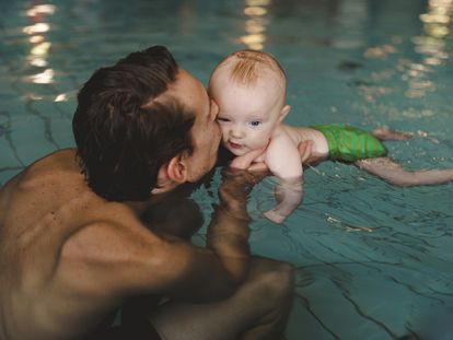 Un padre en la piscina con su bebé.
