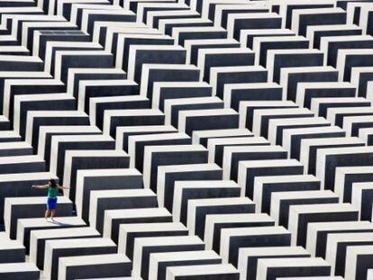 Una mujer camina sobre los bloques del Memorial a las víctimas del Holocausto en Berlín.