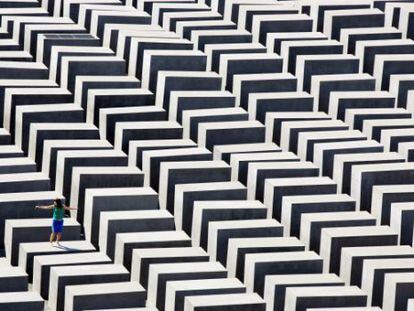 Una mujer camina sobre los bloques del Memorial a las v&iacute;ctimas del Holocausto en Berl&iacute;n.