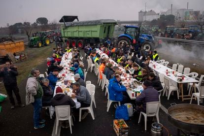 Agricultores comen juntos tras bloquear la autopista cerca de Mollerussa, en Lleida, este martes.