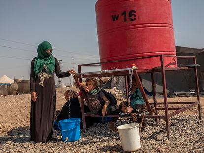 Una mujer de Homs desplazada en el campamento de Al Alsadya, cerca de la ciudad de Raqa, llena un cubo en el tanque del campamento, la única fuente de agua disponible.