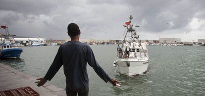 Un vecino de Barbate recibe en el puerto a uno de los pesqueros que regresaron este jueves de Marruecos.